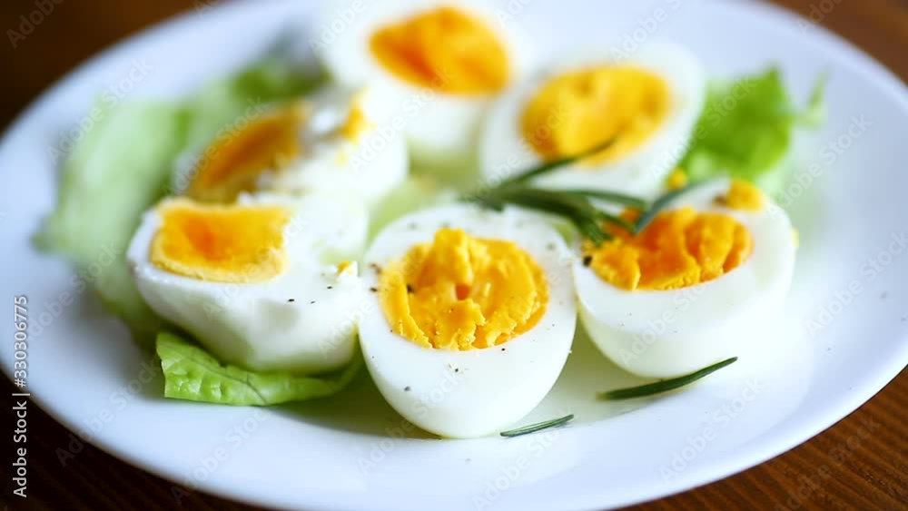 boiled eggs with salad leaves in a plate on a wooden table boiled eggs with salad leaves in a plate on a wooden table