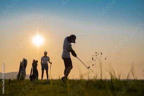 Fototapeta Naklejka Na Ścianę i Meble -  couple lover playing golf together in the course, try to keep golf ball away from the rough to fairway, difficult time stay together in the family concept