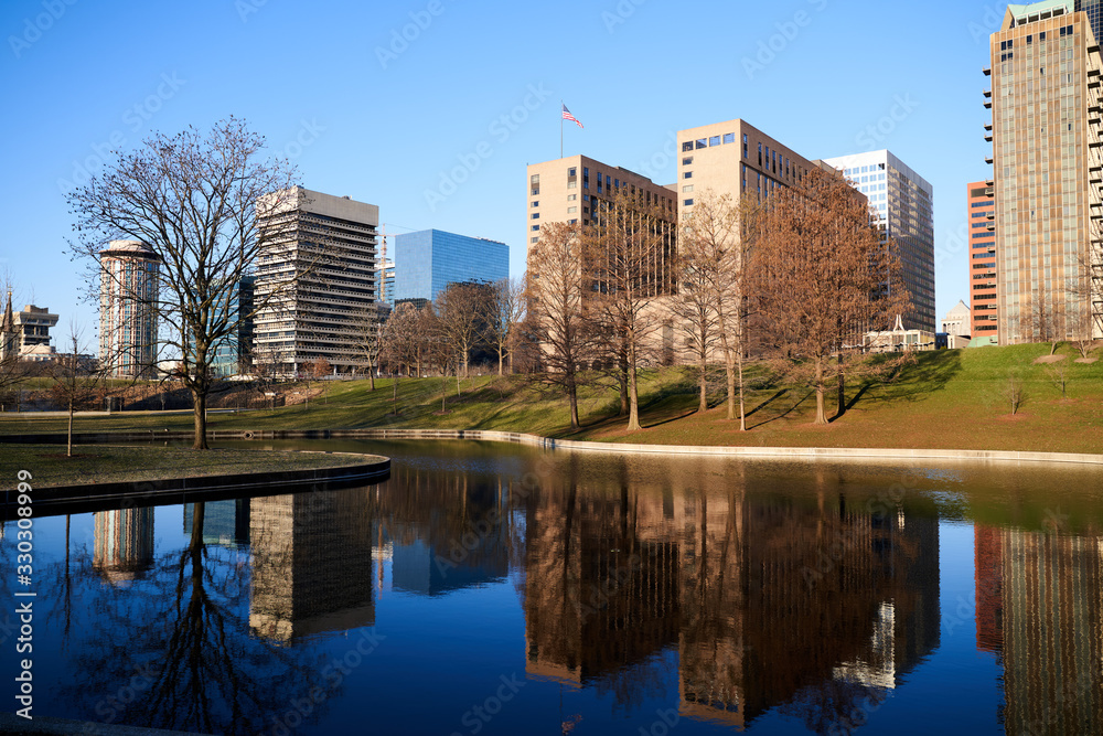 Scenic view of St Louis, Missouri City skyline with building reflection in park lake 