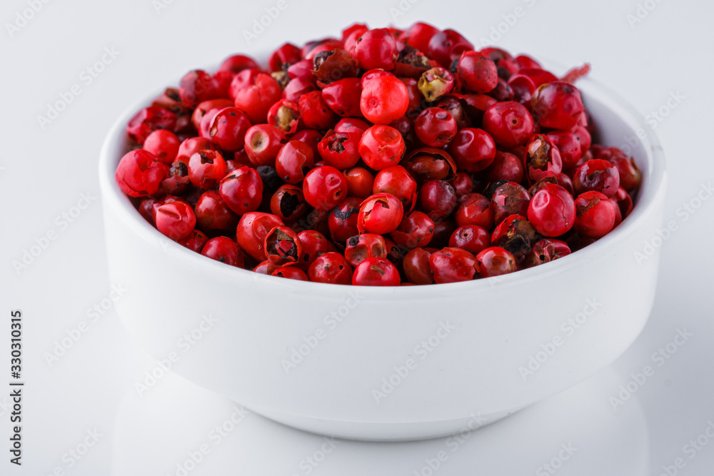 fragrant pink peppercorns on white acrylic background