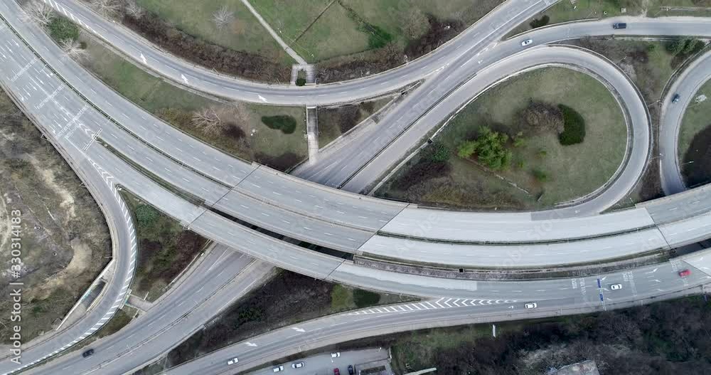 Top down view of highway multi level junction road with moving cars. View of traffic jam passing through city center