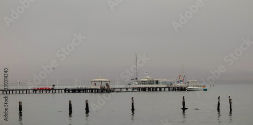 Paracas/Peru - wooden deck in a misty day at local beach. Ica district photo