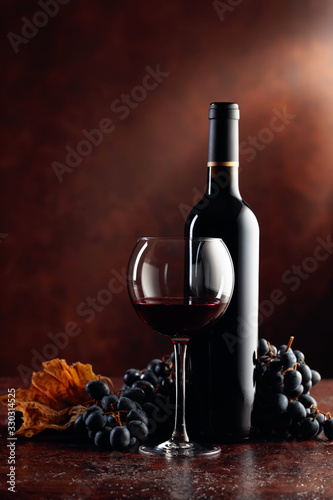 Red wine and grapes on a brown background.