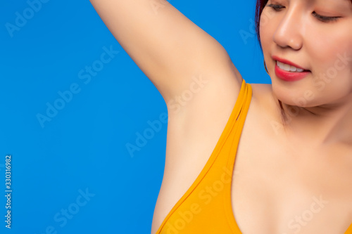 Beauty asian woman look at beautiful underarm, armpit without armpit hair, smile happy, hair removal. Young girl clean underarm, whitening armpit. She show nice armpit. It look smooth skin, satisfy it