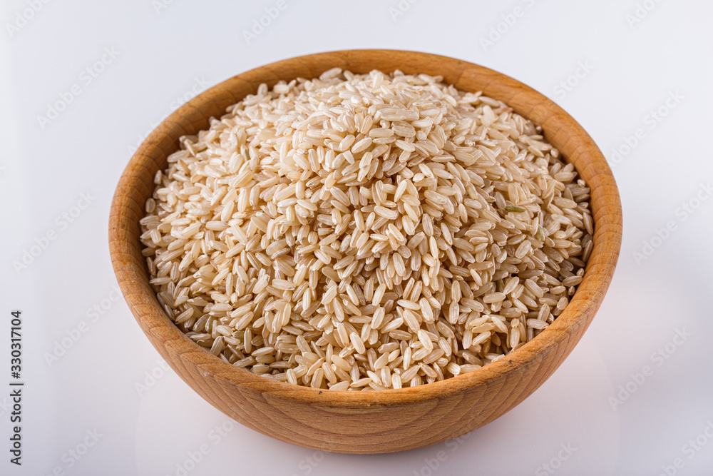 raw brown rice on white acrylic background raw brown rice on white acrylic background