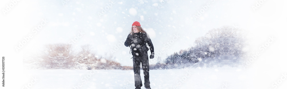 Obraz premium A man travels with a backpack. Winter hike in the forest. Tourist on a walk in the winter in the park.