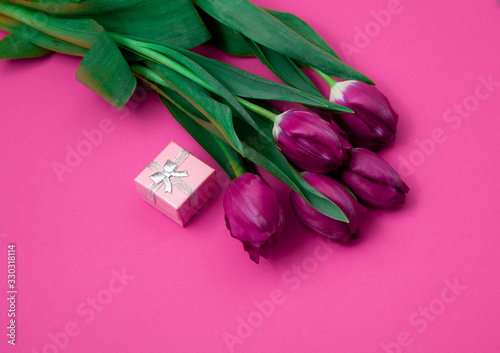 Fototapeta Naklejka Na Ścianę i Meble -  Bouquet of pink tulips on a pink paper background. Spring card mockup with place for text. Five flowers tulip close-up. 