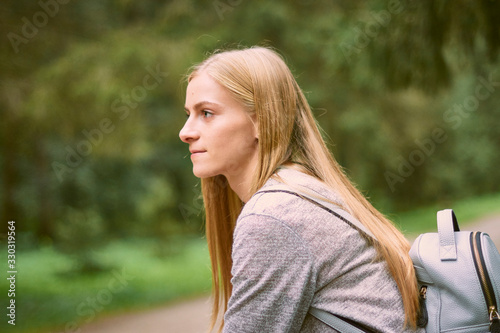 Beautiful young woman is walking in the park. Young woman enjoying nature