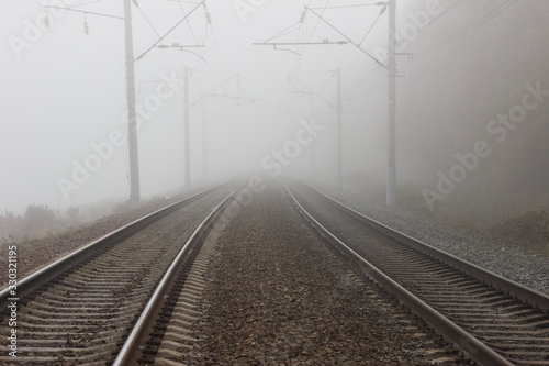 Two parallel tracks of the railway, going into the distance into fog and suspense.