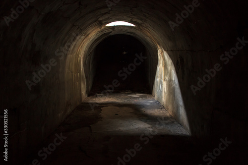 A gloomy  scary mystical underground passage with a skylight in the ceiling  attending a dark corridor  at Pospelov Fort on the Russian island in Vladivostok.