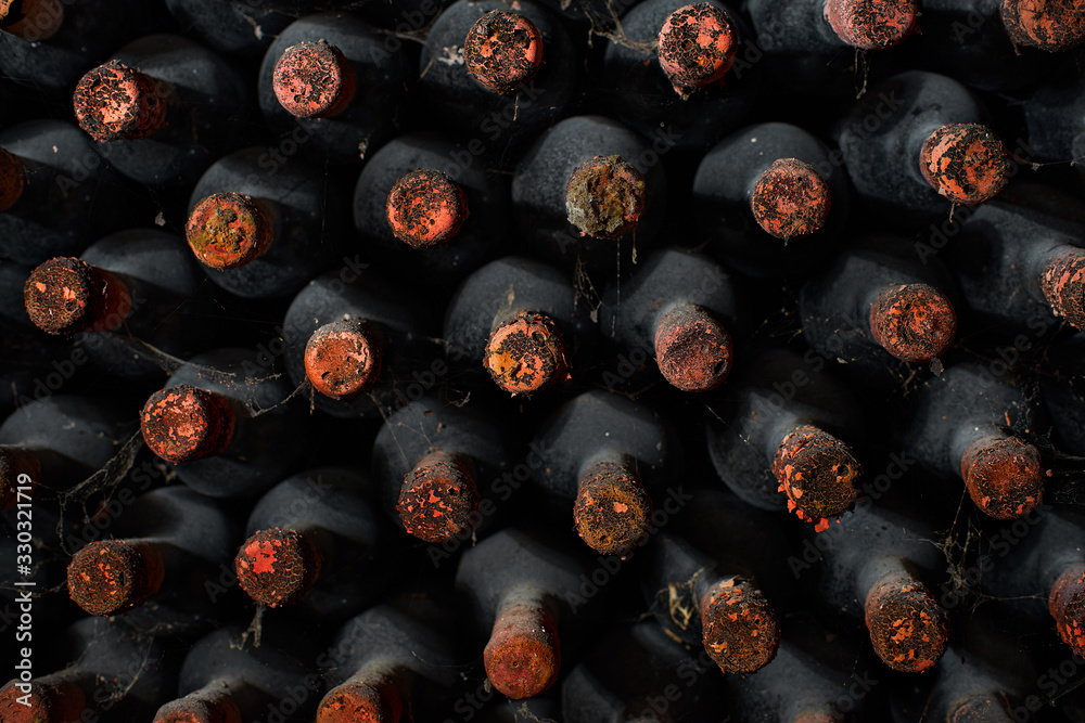 Dusty wine bottles on shelfs in cellars of winery