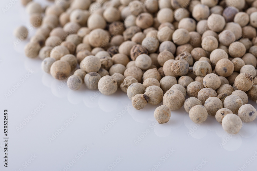 white peppercorns seed on white acrylic background white peppercorns seed on white acrylic background