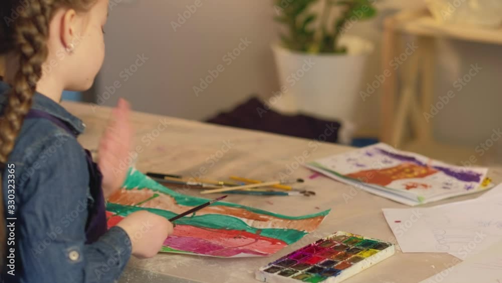 Out-of-school activities. Painting hobby. Inspired girl creating abstract artwork with watercolor. Out-of-school activities. Painting hobby. Inspired girl creating abstract artwork with watercolor.