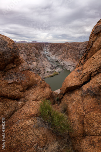 A beautiful vertical landscape view of the Augrabies Falls Gorge  mountains and river in South Africa  taken on a windy and stormy cloudy afternoon.