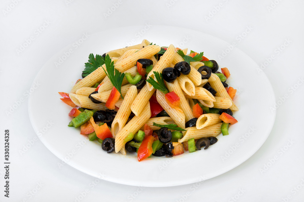 Pasta in red pepper with vegetables and olives on a plate on a white background Pasta in red pepper with vegetables and olives on a plate on a white background