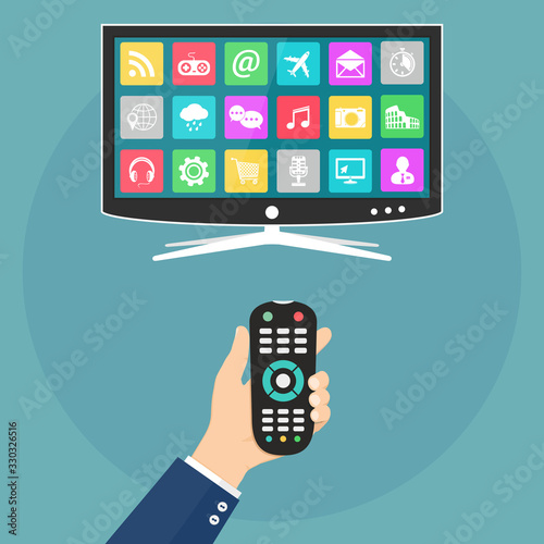 Hand holding remote control and smart tv with apps icons on screen