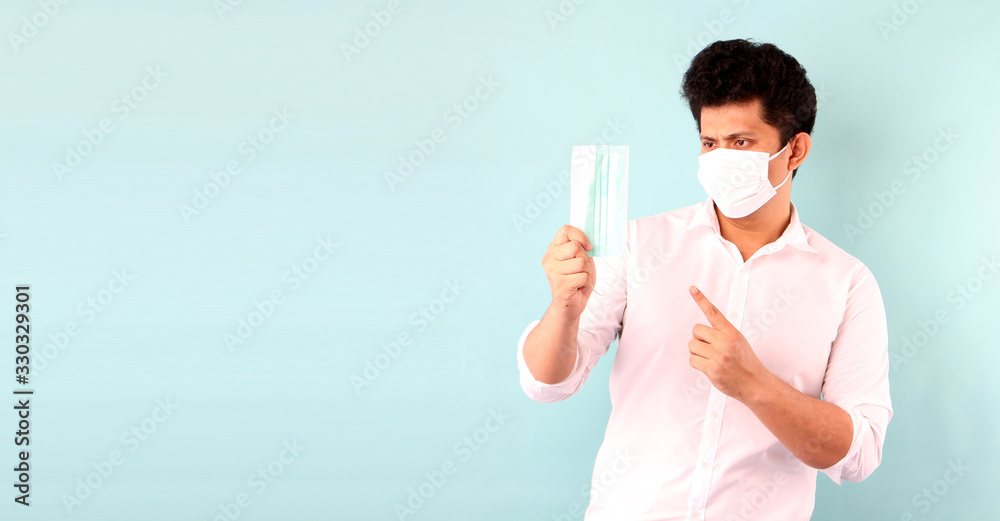 Portrait of handsome Asian man Suggest how to using mask and wearing medical mask,Recommend the prevention of viruses and various diseases. isolated on blue background in studio With copy space. Portrait of handsome Asian man Suggest how to using mask and wearing medical mask,Recommend the prevention of viruses and various diseases. isolated on blue background in studio With copy space.