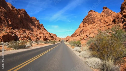 4K. POV view of car driving on road of highway at day in USA. Drive on an empty road in the dark evening. Asphalt with yellow line at new road in Valley of Fire. Nevada state.