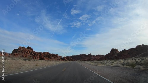 4K. POV view of car driving on road of highway at cloudy day in USA. Drive on an empty road in the dark evening. Asphalt with yellow line at new road in Valley of Fire. Nevada state.