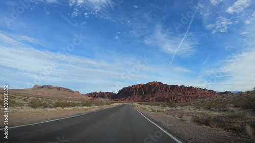 4K. POV view of car driving on road of highway at cloudy day in USA. Drive on an empty road in the dark evening. Asphalt with yellow line at new road in Valley of Fire. Nevada state.