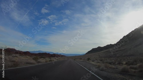 4K. POV view of car driving on road at sunny day in USA. Drive on an empty road in the dark evening. Asphalt with yellow line at new road in Valley of Fire. Nevada state.