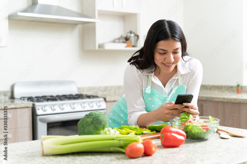 Smiling Attractive Housewife With Smartphone At Home