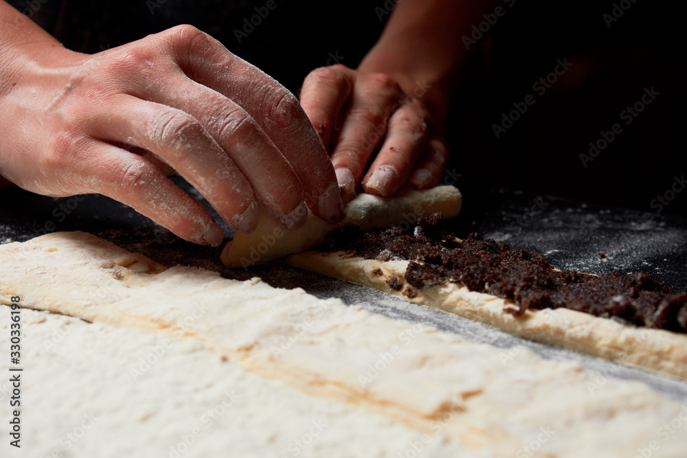 Baker prepares homemade cakes. Professional Female cook sprinkles dough with flour, prepared for baked bread