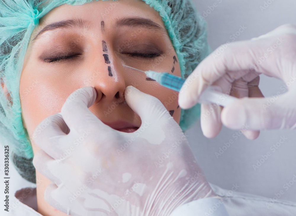 Plastic surgeon preparing for operation on woman face Plastic surgeon preparing for operation on woman face