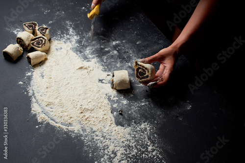 Baker prepares homemade cakes. Professional Female cook sprinkles dough with flour, prepared for baked bread