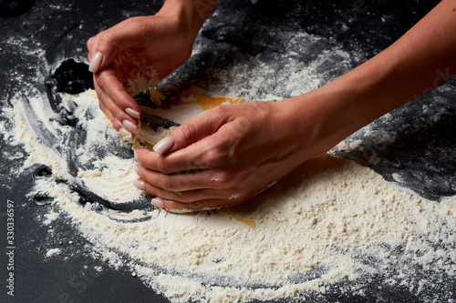 Baker prepares homemade cakes. Professional Female cook sprinkles dough with flour  prepared for baked bread
