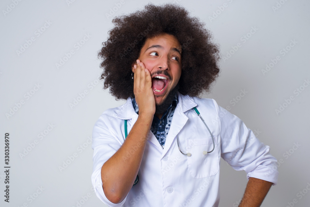 Amazement - doctor man excited looking to the side with hand on face. Surprised happy young woman looking sideways in excitement. Amazement - doctor man excited looking to the side with hand on face. Surprised happy young woman looking sideways in excitement.