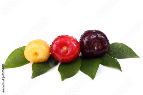 Different color cherries on leaves