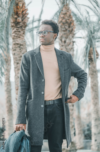 Young and black businessman looking towards the sea © Sara