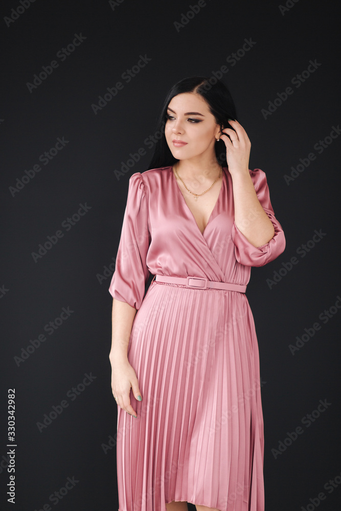 Beautiful model demonstrating spring dress. Young brunette on black background Beautiful model demonstrating spring dress. Young brunette on black background