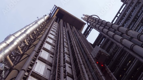 Elevator rises up outside the Lloyd Building. Bottom-up perspective of the Lloyd's modern building. High business center in the center of London near Gherkin Or 30 St Mary Axe Commercial Skyscraper