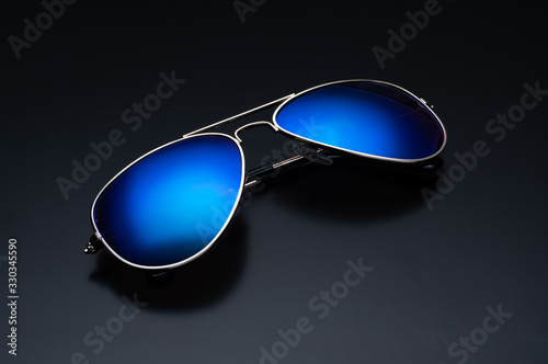 Sunglasses on black. Sunglasses with bright blue glasses.