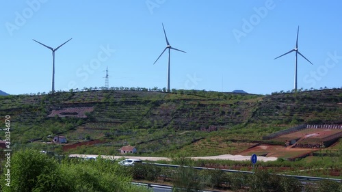 Aerogeneradores, molinos de viento se mueven por el viento en una ladera sobre una autovía del sur de España