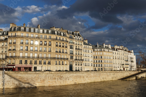The traditional French house with typical balconies and windows located on parisian quay . Paris.