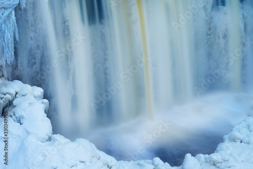 Winter, Upper Tahquamenon Falls framed by ice and captured with motion blur, Michigan's Upper Peninsula, USA