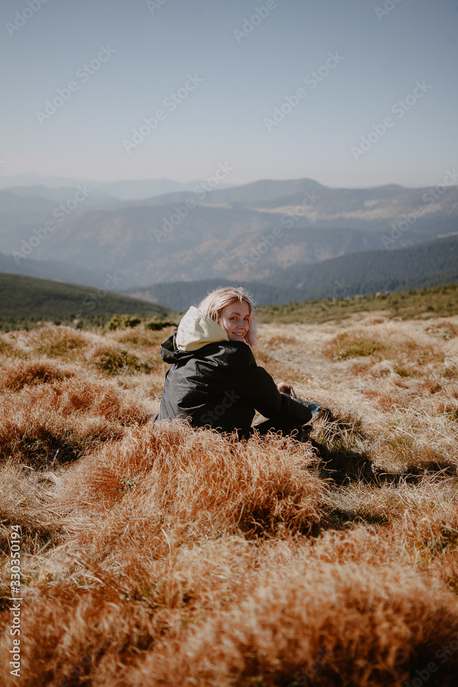 girl sitting on top and looking at the mountains