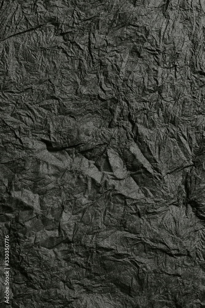 Abstract colorful background. Texture of crumpled black paper. Top view of black crumpled paper. Abstract black background. Textured colorful black backdrop. Vertical, free space, close-up, toning. Abstract colorful background. Texture of crumpled black paper. Top view of black crumpled paper. Abstract black background. Textured colorful black backdrop. Vertical, free space, close-up, toning.