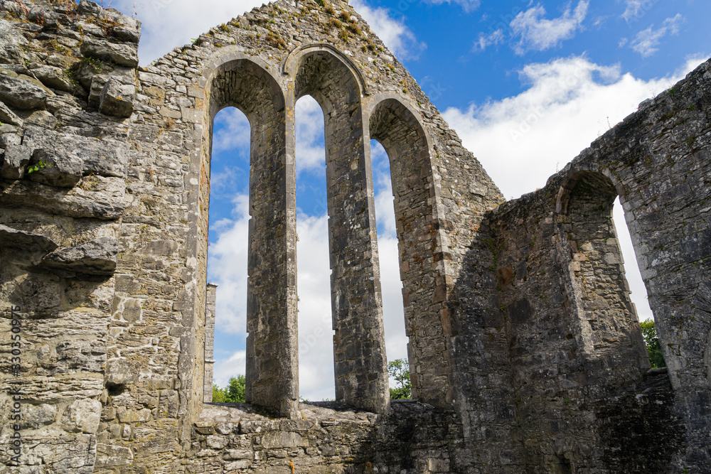 Panoramic view of the ruins of Cong Abbey in County Mayo in Ireland, blue cloud and white clouds.