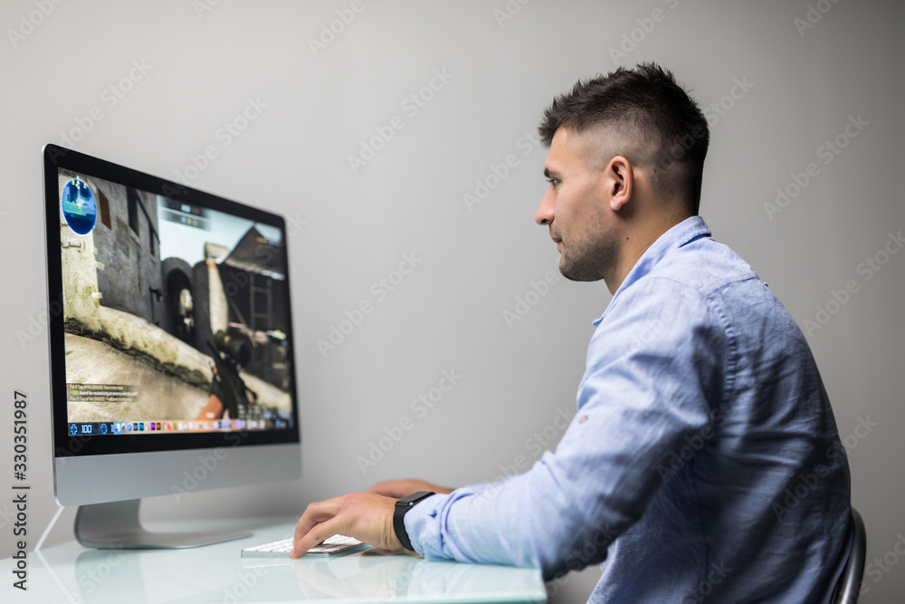 Professional gamer playing in first-person shooter online video game on his personal computer. Professional gamer playing in first-person shooter online video game on his personal computer.