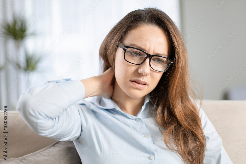 Young woman feeling pain in her neck Young woman feeling pain in her neck