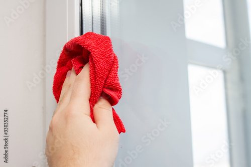cleaning glass window with a red microfiber cloth