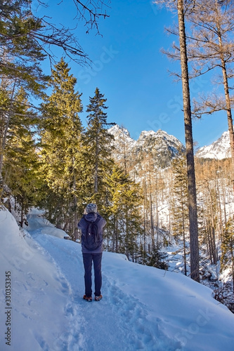 Rear view of a tourist taking a photo with his smartphone in High Tatras, Slovakia.