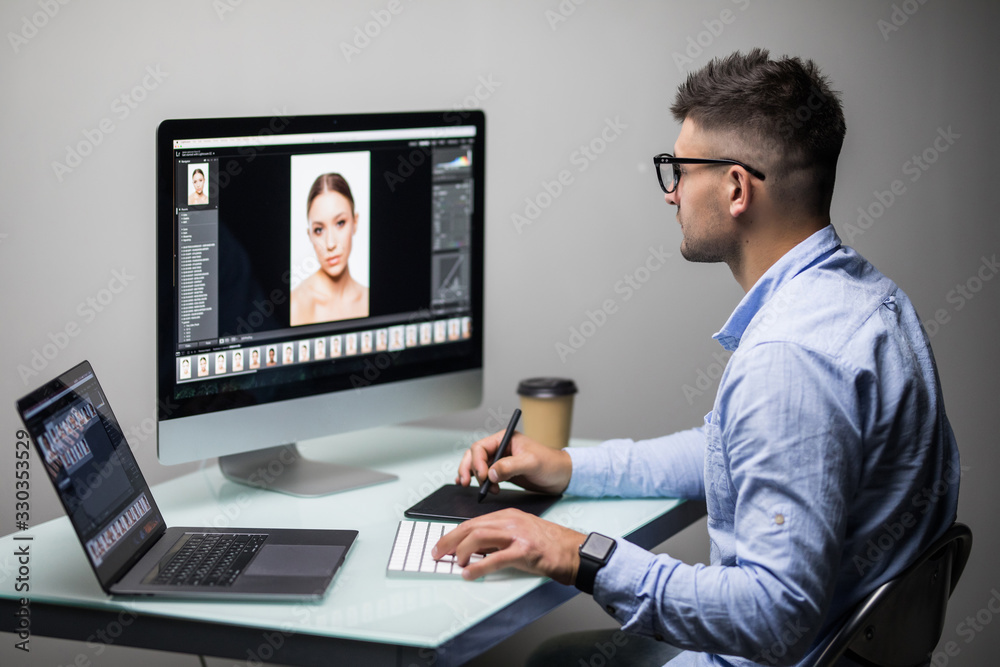 Young man designer editing photo on computer in office Young man designer editing photo on computer in office