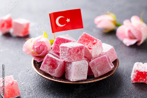 Turkish delight, rose flavour in a copper plate with Turkish flag. Grey background. Close up.