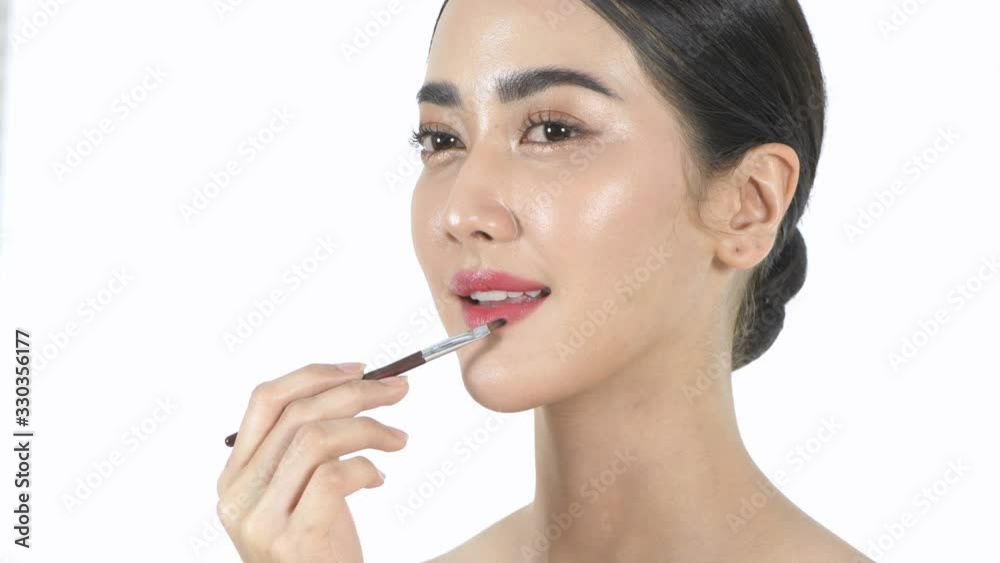 Beauty concept. A young woman wearing bright lipstick on a white background. 4k Resolution. Beauty concept. A young woman wearing bright lipstick on a white background. 4k Resolution.