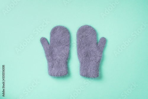 Christmas and New Year cozy holiday composition. Knitted mittens on blue background. Flat lay, top view